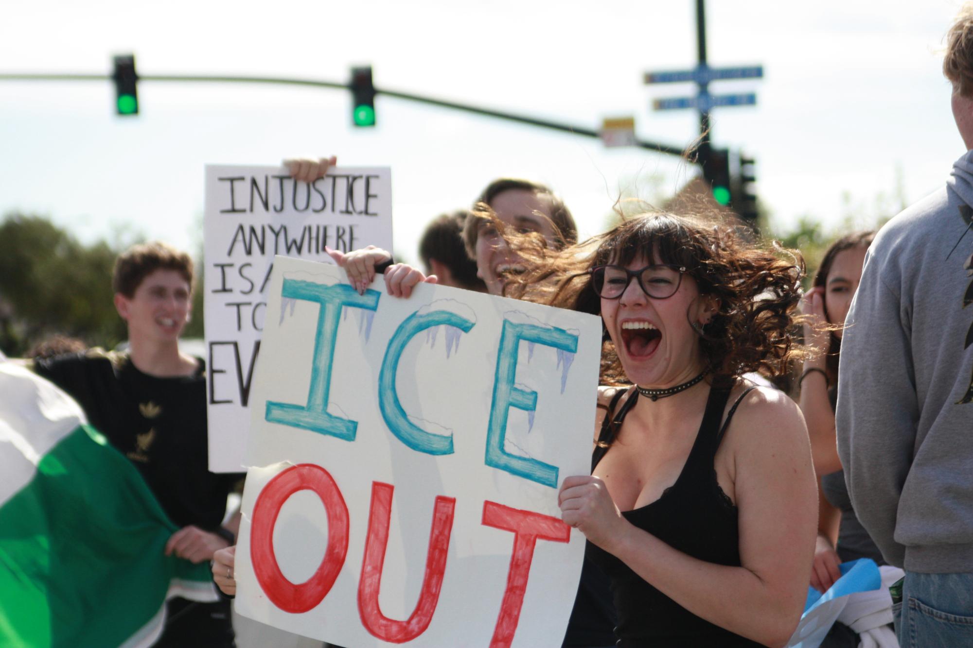 Anneliese Lippmann (12) yells at oncoming traffic in protest of ICE. Lippmann's sign reads "ICE OUT."