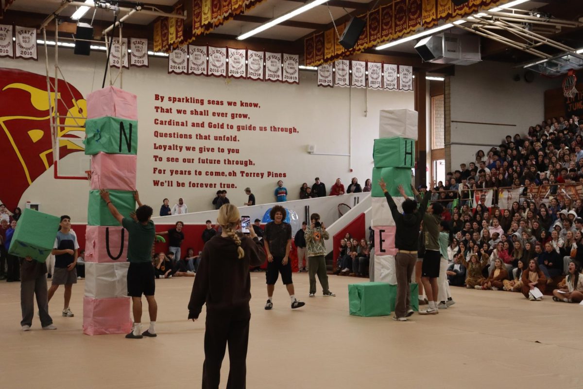 The boys soccer team and the boys basketball team compete in a block stacking race. The boys basketball team won the pep rally games on Feb. 11.