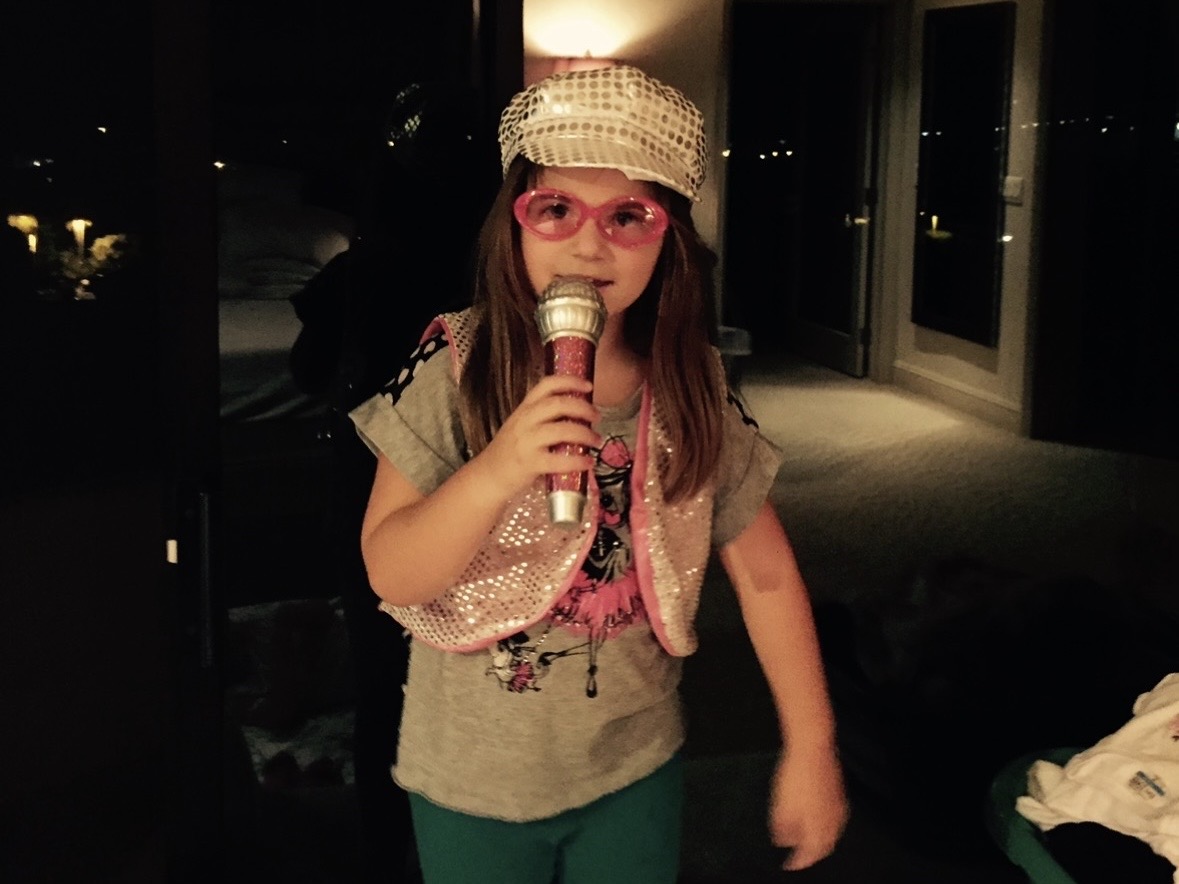 Priscilla Akin (10) holds a microphone and sings. Akin was five years old when the photo was taken.