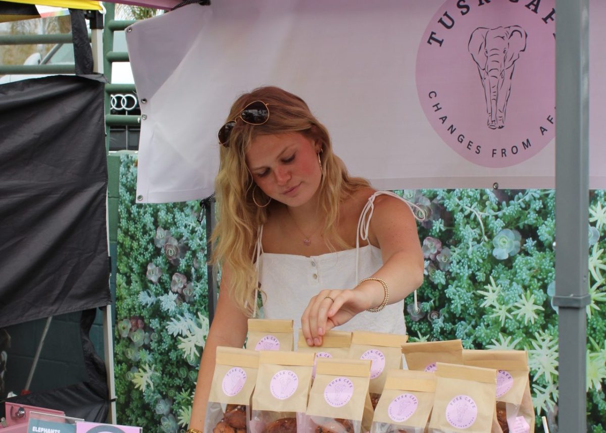Lila Swortwood (11) adjusts the pre-packed chocolate chip cookies at the Solana Beach Farmer's Market. Swortwood has been working on the establishment of the Tusk Cafe for the past few months. Photo courtesy of Lila Swortwood.